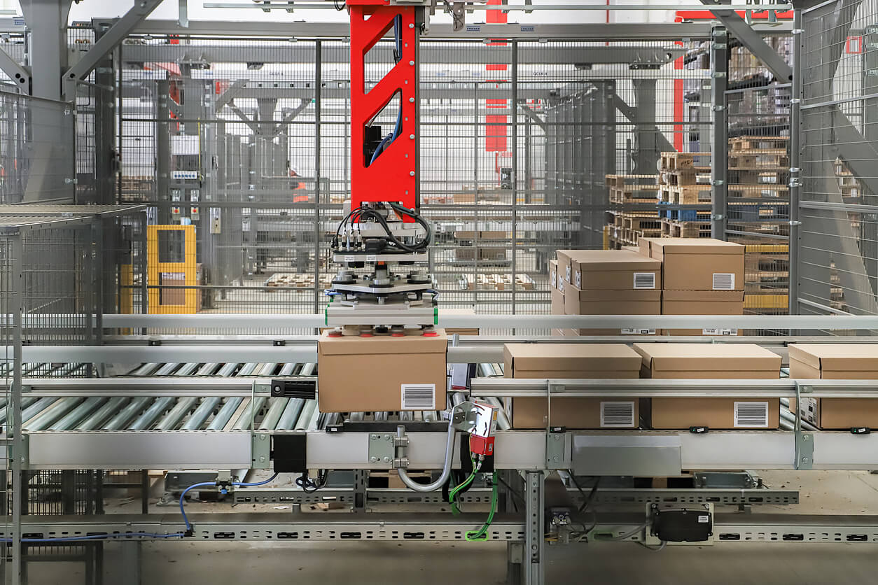 Robotic arms integrated with high-speed conveyors automating packaging operations in an industrial facility.